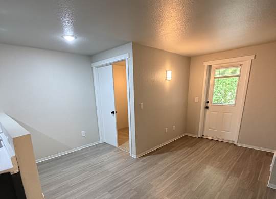 A room with light brown flooring and white walls.
