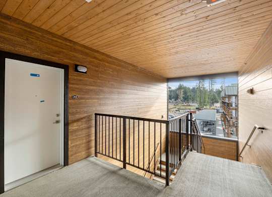 A room with a wooden ceiling and a white door.