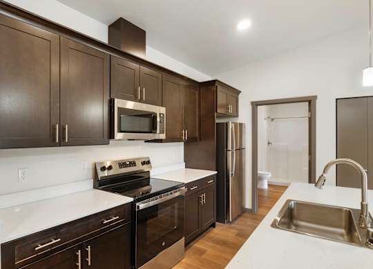 A kitchen with dark brown cabinets and stainless steel appliances.