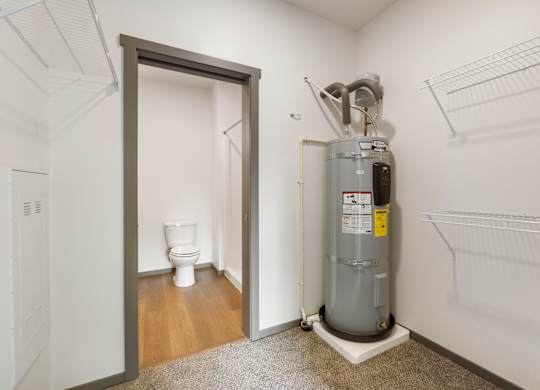 A room with a toilet, a heater and a door.