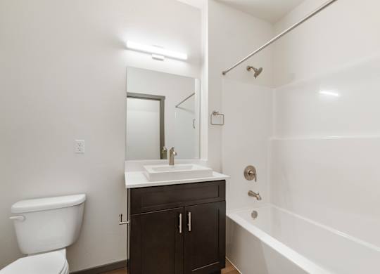 A white bathroom with a toilet, sink, and bathtub.