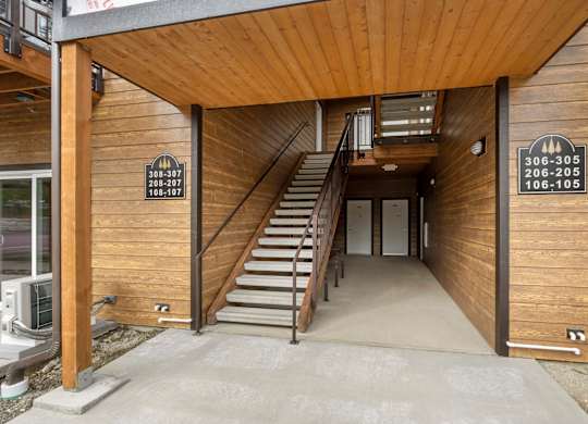 A wooden building with a staircase leading to the second floor.