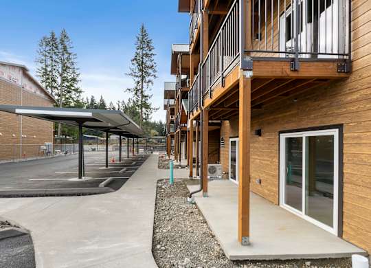 A long wooden building with a balcony and a covered walkway.