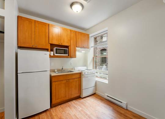 A kitchen with wooden cabinets and white appliances.