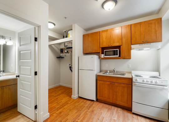 A kitchen with white appliances and wooden cabinets.