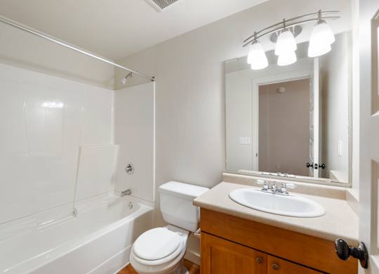 A white bathroom with a toilet, sink, and bathtub.