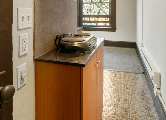 A kitchen with a wooden cabinet and a window.