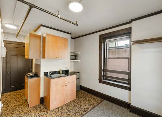 A kitchen area with wooden cabinets and a black countertop.