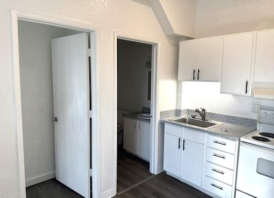 A kitchen with white appliances and cabinets.