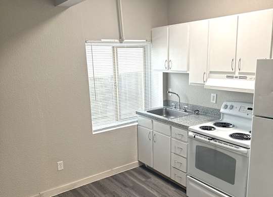 A kitchen with white appliances and wooden cabinets.