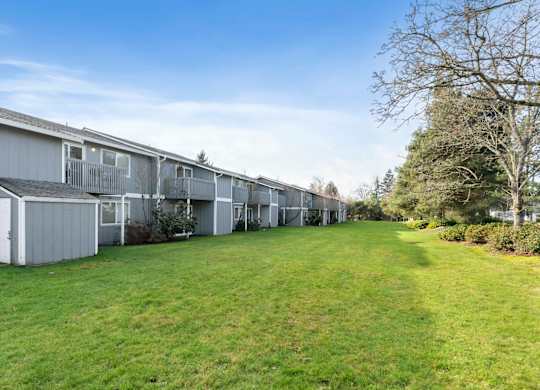 A long row of houses with green lawns in front.