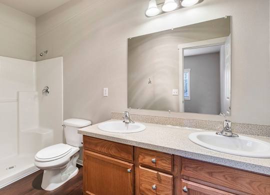 Bathroom with two sinks, toilet, and shower
