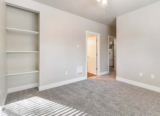 Primary bedroom with carpeting and a doorway leading to the bathroom