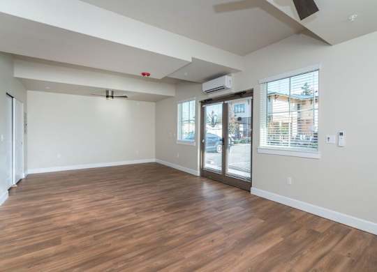 Studio apartment living space with double doors to patio and ceiling fan