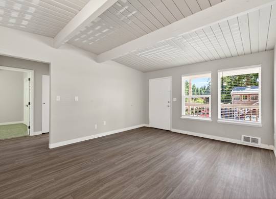 A room with a white ceiling and wooden flooring.