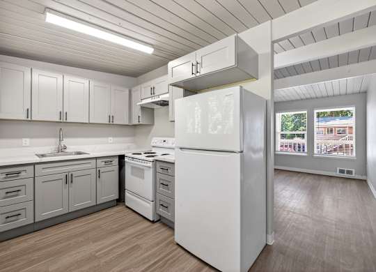 A kitchen with white appliances and cabinets.