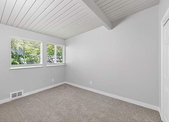 A room with a white ceiling and carpeted floor.