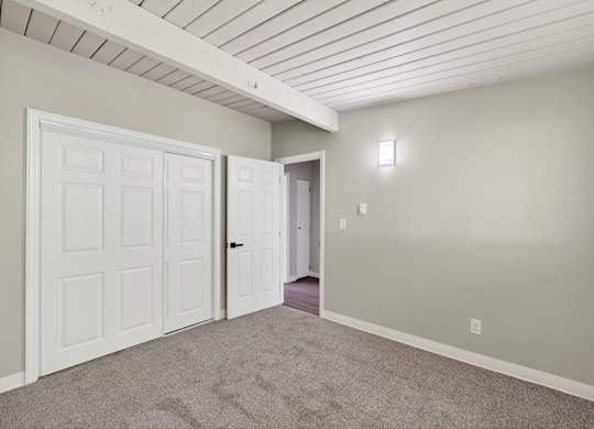 A room with a white door and carpeted floor.
