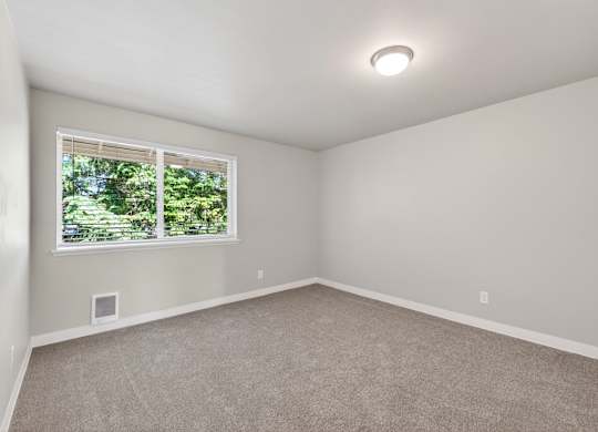 A room with a window and carpeted floor.