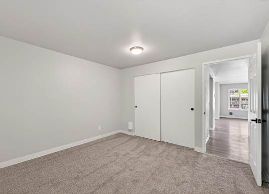 A room with a carpeted floor and white walls.