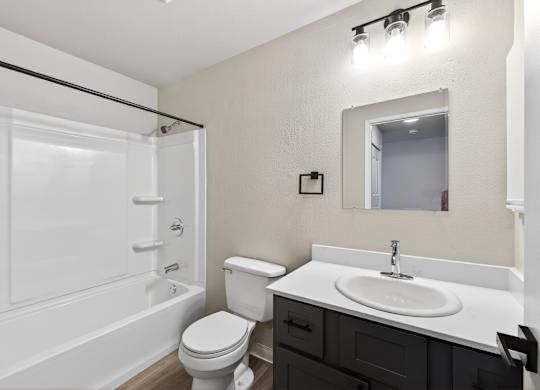 A white bathroom with a toilet, sink, and bathtub.
