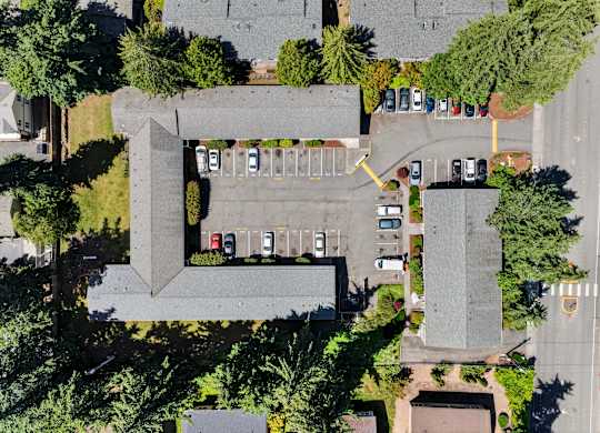 A parking lot with cars and a building in the background.