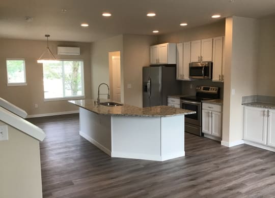 a kitchen with a center island and a stainless steel refrigerator