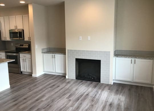 a renovated living room with white cabinets and a fireplace