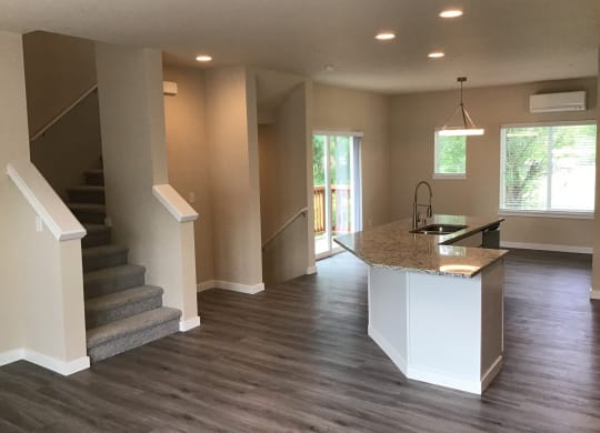 a view of a living room with a staircase and a kitchen