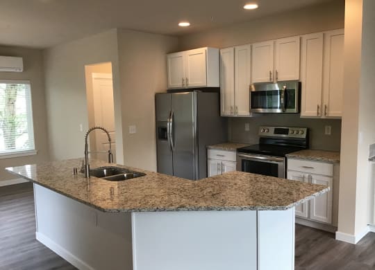 a kitchen with white cabinets and a granite counter top