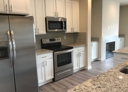 a kitchen with stainless steel appliances and white cabinets