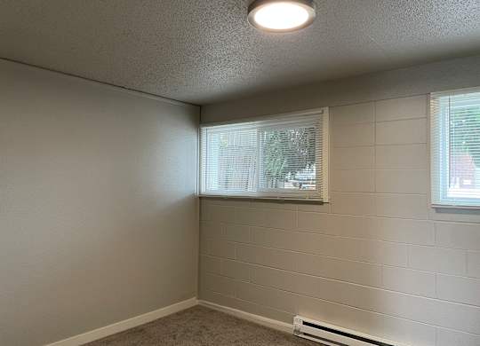 A room with a window and a wall-mounted air conditioner.