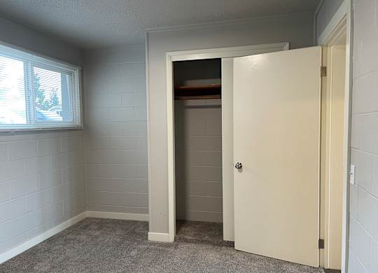 A white door is open to a small storage space.