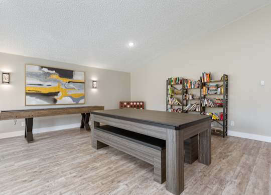 Community Clubhouse library and lounge space with seating, large table, book shelves, and yard games
