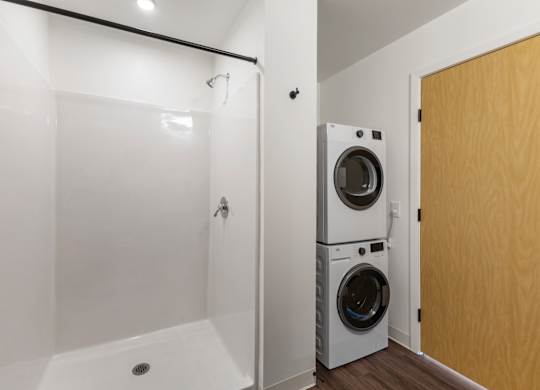 A bathroom with a washer and dryer in it at The Hub Apartments, Lacey, Washington
