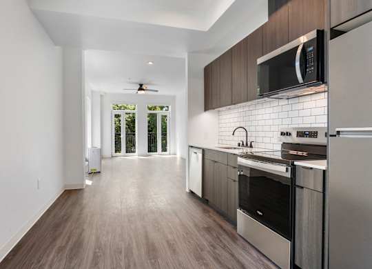 A modern kitchen with stainless steel appliances and wooden cabinets at The Hub Apartments, Lacey, 98503