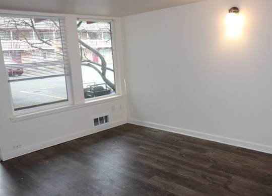 Living room for 2 bedroom apartment with large windows and vinyl plank dark wood flooring at Horizon Park Apartments