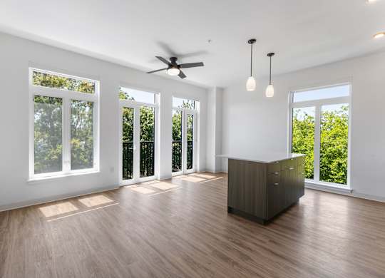A spacious room with a ceiling fan and sliding glass doors at The Hub Apartments, Washington 98503
