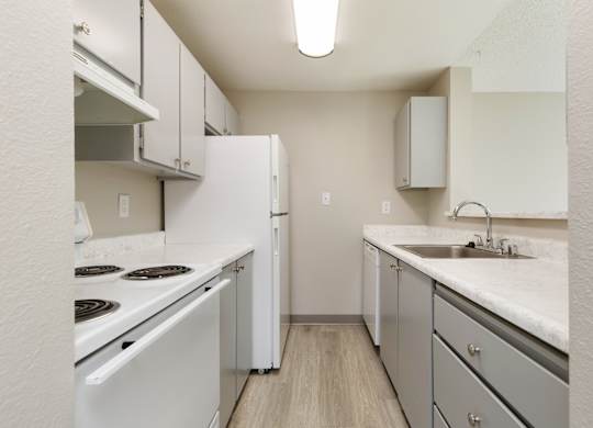 A kitchen with white appliances and grey cabinets.