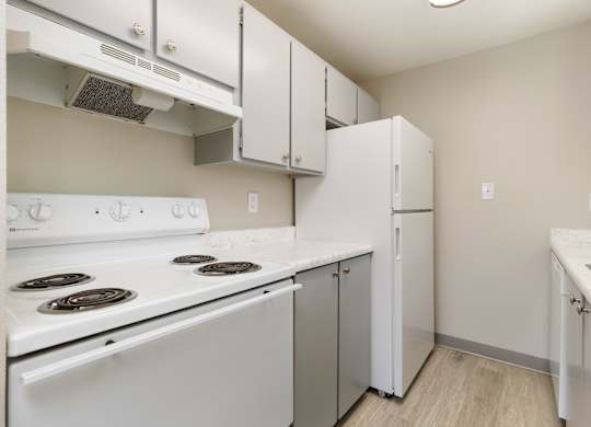 A kitchen with white appliances and cabinets.