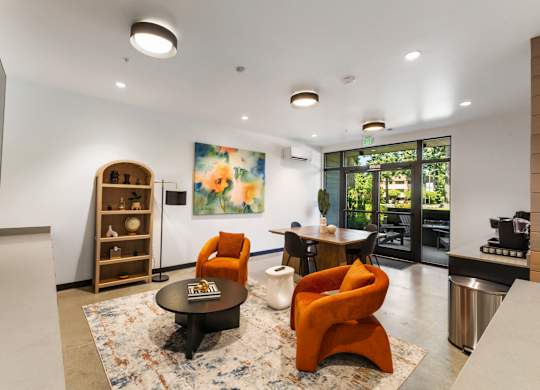 A living room with a rug, a chair, a table, and a painting on the wall at The Hub Apartments, Lacey, 98503