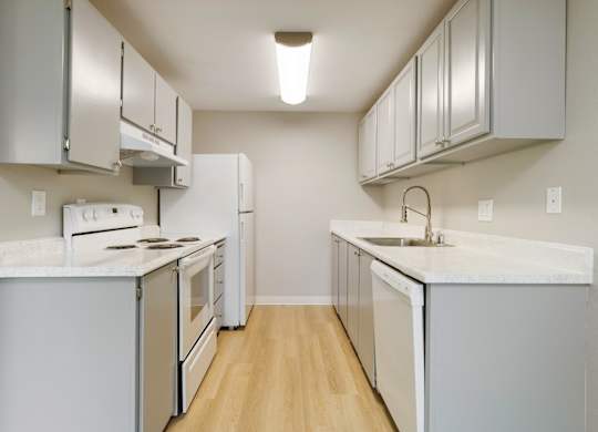 A kitchen with white appliances and cabinets.