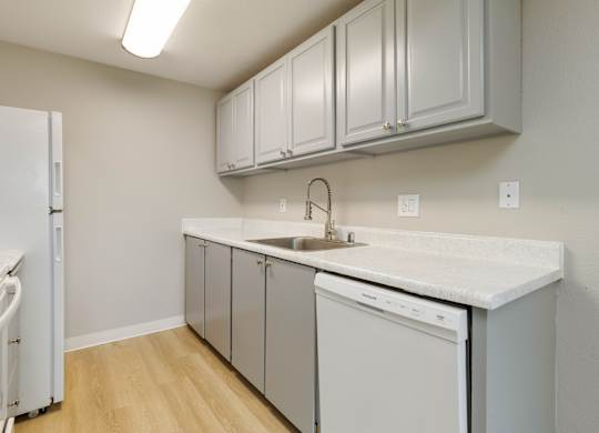 A kitchen with white appliances and grey cabinets.