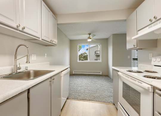 A kitchen with white cabinets and a stove top oven.