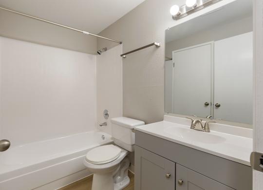 A bathroom with a toilet, sink, and bathtub.