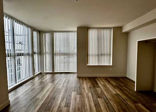 Large 1-bedroom living space at Bode-88 apartment homes with luxury vinyl plank floors and large windows with coverings