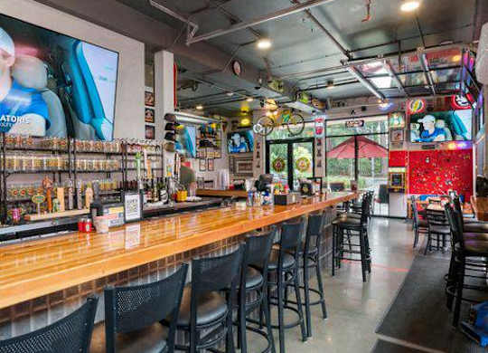A bar with black chairs and a wooden counter at The Hub Apartments, Washington 98503