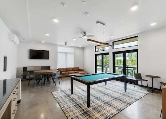 A room with a pool table and a television at The Hub Apartments, Lacey, WA