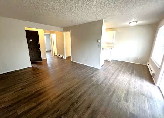 A room with wooden flooring and white walls.