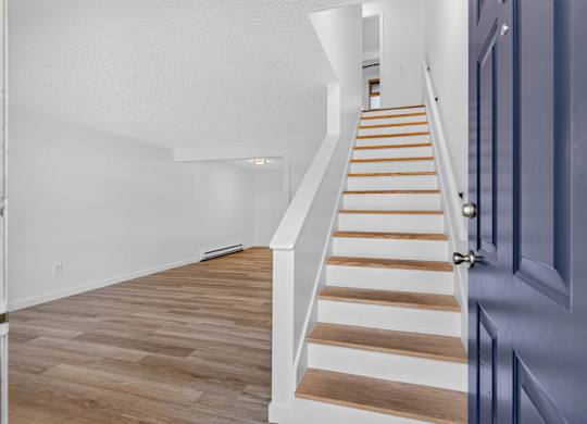 A staircase with wooden steps and a blue door.